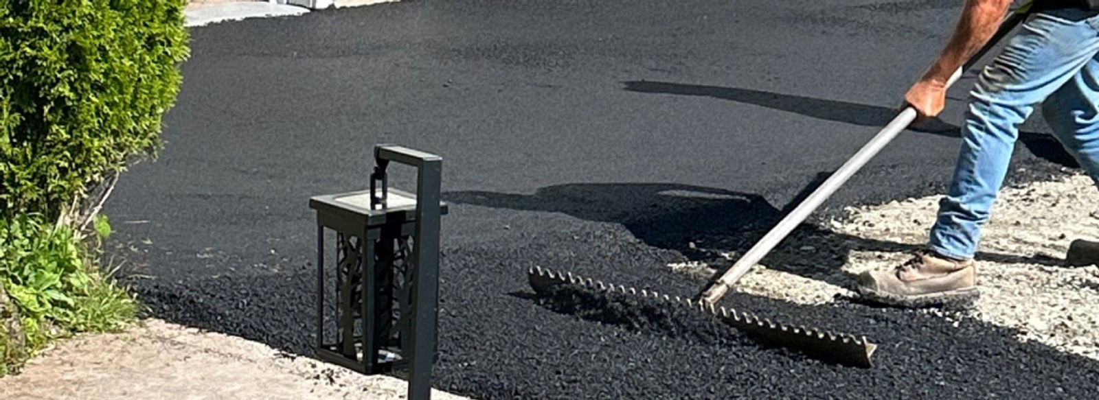 Man paving street in front of a house